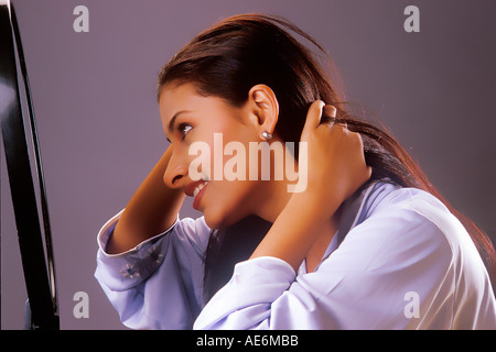 South Asian Indian Girl coiffure Haar mit Hände vor einem Spiegel Modell Release Nummer 442 Stockfoto