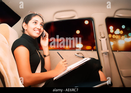RHS70952 South Asian junge executive Inderin sitzen bequem in teuren Auto sprechen auf mobile Model Release 522 Stockfoto