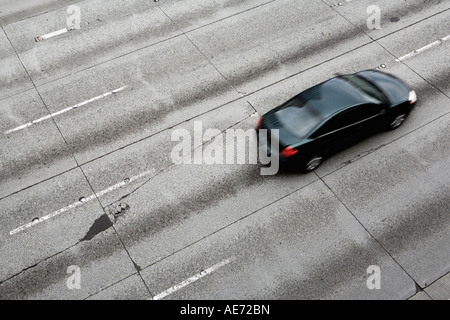 Betonstraße Autobahn mit Rissen und Patches und Auto fahren drauf getragen Stockfoto