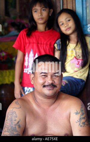 Mann mit Tattoos und schöne junge Mädchen, Rumah Engking, eine traditionelle Iban-Langhaus, Kuching, Sarawak, Borneo, Malaysia Stockfoto