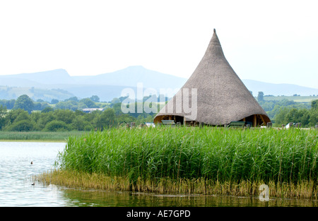 Rekonstruktion der alten Eisenzeit Crannog am Llangorse See Powys South Wales UK mit Pen y Fan in Ferne Stockfoto