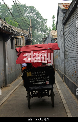 Touristen auf einem Beijing Hutong-Tour in einer Fahrradrikscha Stockfoto