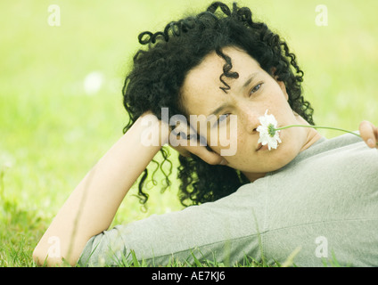Frau am Boden liegen und hält Daisy zur Nase Stockfoto