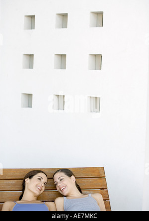 Zwei junge Frauen liegen und reden nebeneinander Stockfoto