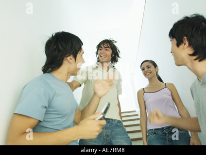 Vier junge Freunde treffen im Treppenhaus Stockfoto