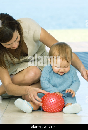 Frau sitzt auf dem Boden spielen mit baby Stockfoto