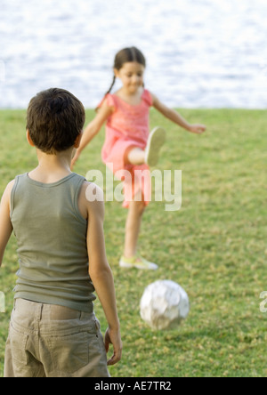 Jungen und Mädchen Fußball spielen Stockfoto