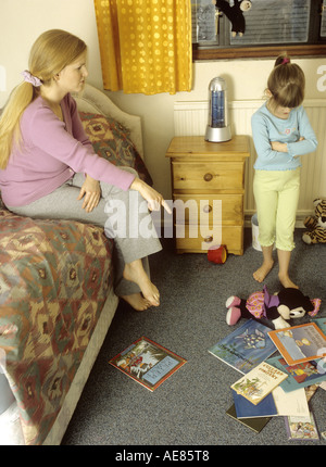 Mutter erzählte Sie ihr Kind in ihrem chaotisch Schlafzimmer Stockfoto