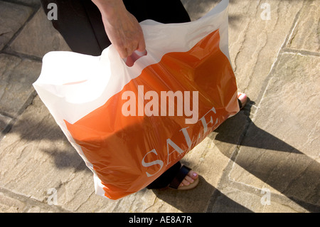 Frau, die ein einzelnes Verwenden von nicht wiederverwertbaren Kunststoff Shopping Bag England UK Vereinigtes Königreich GB Grossbritannien Stockfoto