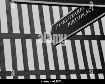 Wegweiser für Shakespeares Geburtshaus gegen einen Schwarzen und Weißen adobe Tudor House Außenwand, Stratford-upon-Avon, Warwickshire Stockfoto