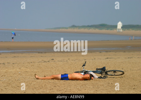 Burnham auf Meer Strand und Leuchtturm von Mensch und Berg Bike ein Sonnenbad im Vordergrund Stockfoto