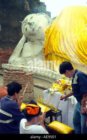 Wat Yai Chai Mongkol mit Gläubigen bei der große liegende Buddha in einer attraktiven archäologische Umgebung in Ayutthaya, Thailand Stockfoto