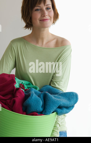 Junge Frau mit Kleidung Korb Stockfoto