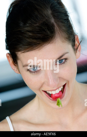 Porträt einer jungen Frau Biss in einen Rettich Stockfoto