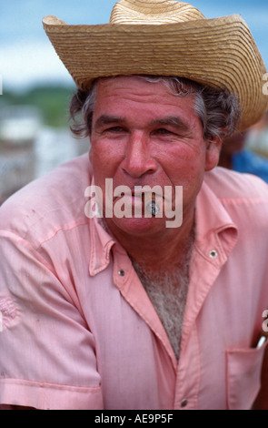 Alter Mann raucht eine Zigarre in einem rosa Hemd bei einem Land Rodeo in Rodas, in der Nähe von Cienfuegos, Kuba Stockfoto