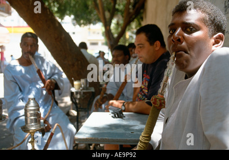 Gruppe von ägyptischen Männer Rauchen von Wasserpfeifen in einem Straßencafé in der Main Bazaar, Assuan, Ägypten Stockfoto