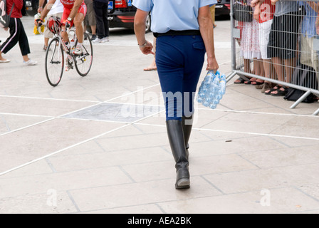 eine verkürzte Ansicht eines französischen Polizisten tragen Flaschen Mineralwasser zu Fuß entfernt von viewer Stockfoto