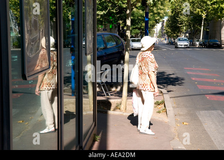 eine ältere weibliche Käufer wartet auf Bürgersteig überqueren Straße Stockfoto