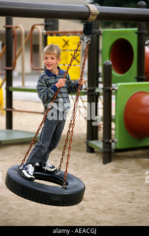 Ein 7 Jahre alter Junge spielt auf einem Reifen-Schaukel-MR Stockfoto