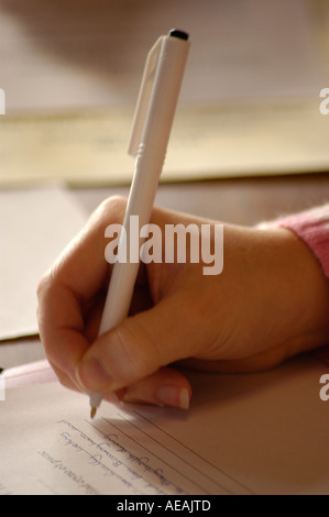 Nahaufnahme von einer Frau Person Hand hält einen Kugelschreiber Stift schreiben Notizen in einer Sitzung des Seminars Vortrag Konferenz Stockfoto