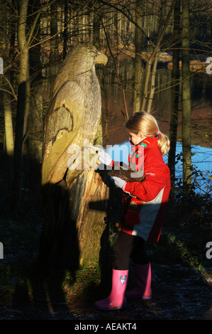 Ein junges Mädchen schaut Woode Skulptur ein Rotmilan Nant yr Arian Forest Park in der Nähe von Ponterwyd Aberystwyth Ceredigion UK Stockfoto