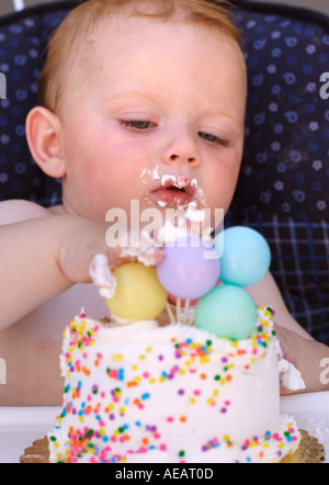 Kleiner Junge an seinem ersten Geburtstag Kuchen essen Stockfoto