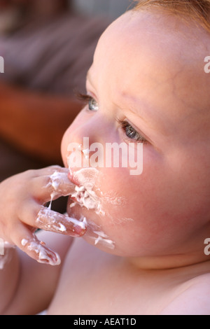 Kleiner Junge an seinem ersten Geburtstag Kuchen essen Stockfoto