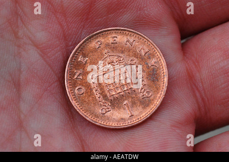 Eine Pence-Münze in die Handfläche. Stockfoto