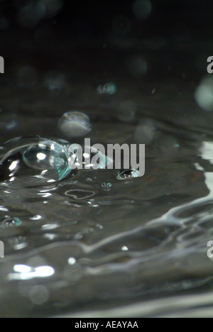 Wassertropfen schlagen Wasserfläche und Schaffung einer reaktiven Form Stockfoto