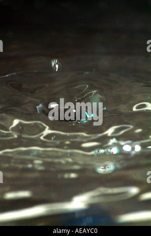 Wassertropfen schlagen Wasserfläche und Schaffung einer reaktiven Form Stockfoto