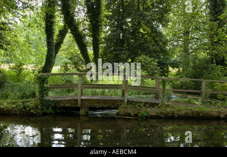 Kleine Holzbrücke über einem Nebenfluss des Flusses Tests auf dem Gelände des Mottisfont Abbey Hampshire Stockfoto