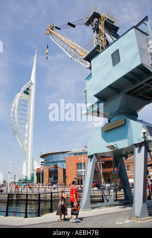 ENGLAND Hampshire Portsmouth Harbour Gunwharf Quay Spinnaker Tower mit Menschen zu Fuß vorbei an einer alten Dockside-Kran Stockfoto