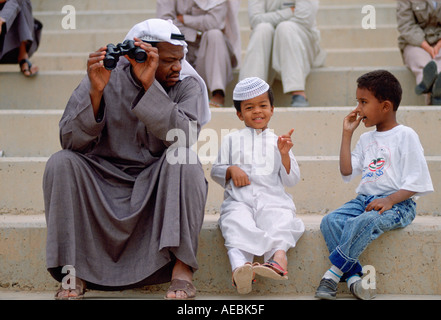 Mann und zwei Jungs sitzen auf Stufen in Kuwait Stockfoto