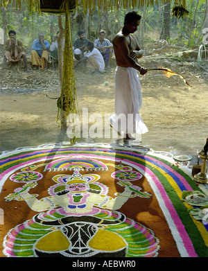 Indisch-hinduistischen Priester darstellende Rituale in einem Tempel mit handgezeichneten Blumenmuster genannt Kalam im Vordergrund Stockfoto