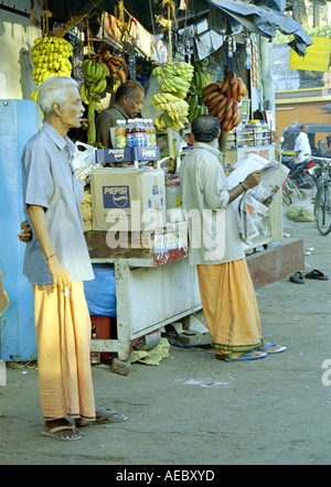 Eine gemeinsame Morgen Szene in Kerala, mit einigen Leuten lesen Zeitungen infront von einem am Straßenrand Teegeschäft, bekannt als Thattukada. Stockfoto