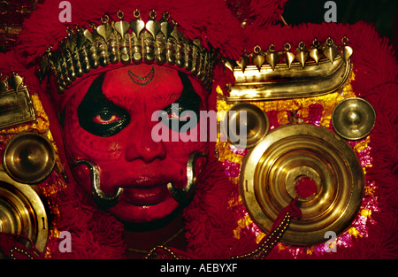 Hautnah ein Theyyam Künstler Gesichts mit traditionellen Form des dunklen Rot machen. Stockfoto