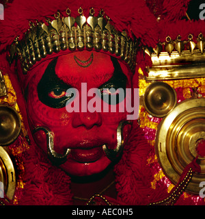 Hautnah ein Theyyam Künstler Gesichts mit traditionellen Form des dunklen Rot machen. Stockfoto