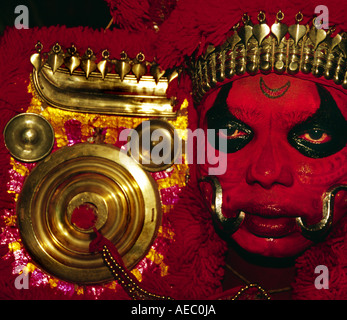 Hautnah ein Theyyam Künstler Gesichts mit traditionellen Form des dunklen Rot machen. Stockfoto