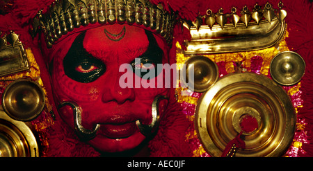 Hautnah ein Theyyam Künstler Gesichts mit traditionellen Form des dunklen Rot machen. Stockfoto