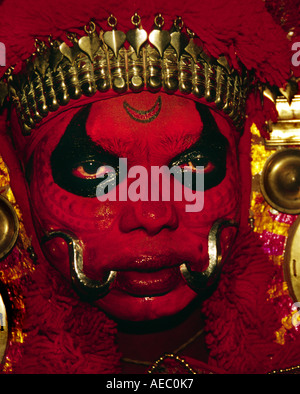 Hautnah ein Theyyam Künstler Gesichts mit traditionellen Form des dunklen Rot machen. Stockfoto