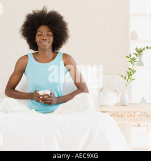 Afrikanerin entspannend auf Bett Stockfoto
