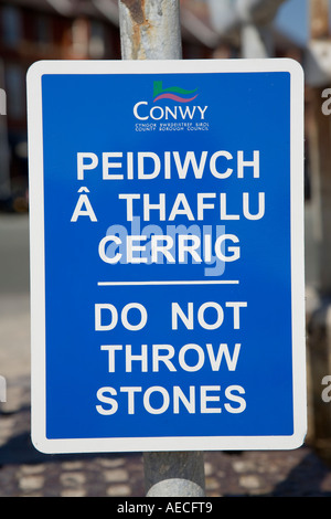 Werfen Sie nicht Steinen zweisprachige zweisprachige Waliser Englisch Warnschild am Strand von Rhos auf Meer Nord Wales UK Stockfoto