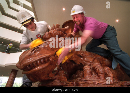 BAU VON CELTIC MANOR HOTEL IN DER NÄHE VON NEWPORT WALES UK JUNI 1999 ZWEI ARBEITER POLIEREN EINEN GESCHNITZTEN HÖLZERNEN DRACHEN Stockfoto