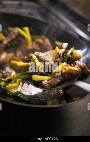 HINEINSCHÜTTEN IM WOK Stockfoto