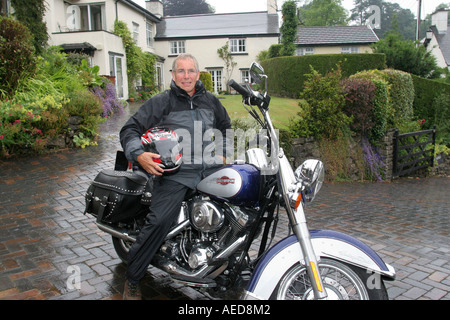 60 Jahre alten Mann mit Harley-Davidson Motorrad außerhalb seines Hauses Leute Lifestyle Wales Stockfoto