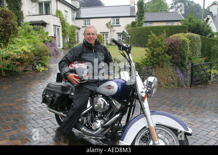 60 Jahre alten Mann mit Harley-Davidson Motorrad außerhalb seines Hauses Leute Lifestyle Wales Stockfoto