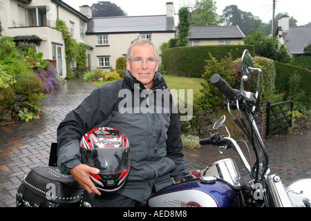 60 Jahre alten Mann mit Harley-Davidson Motorrad außerhalb seines Hauses Leute Lifestyle Wales Stockfoto