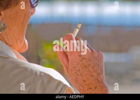 Ältere Frau raucht mit Altersflecken auf Seite hautnah Stockfoto