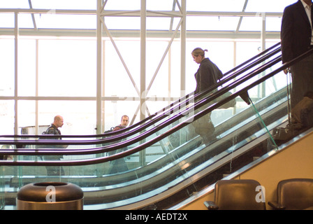 Frau hinunter auf Rolltreppe im Flughafen-terminal Stockfoto
