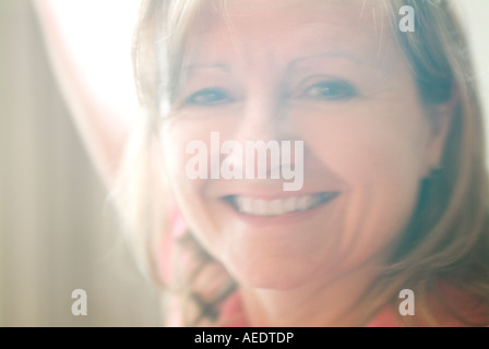 Hübsche Frau lächelnd durch Dunst des Fensters Stockfoto